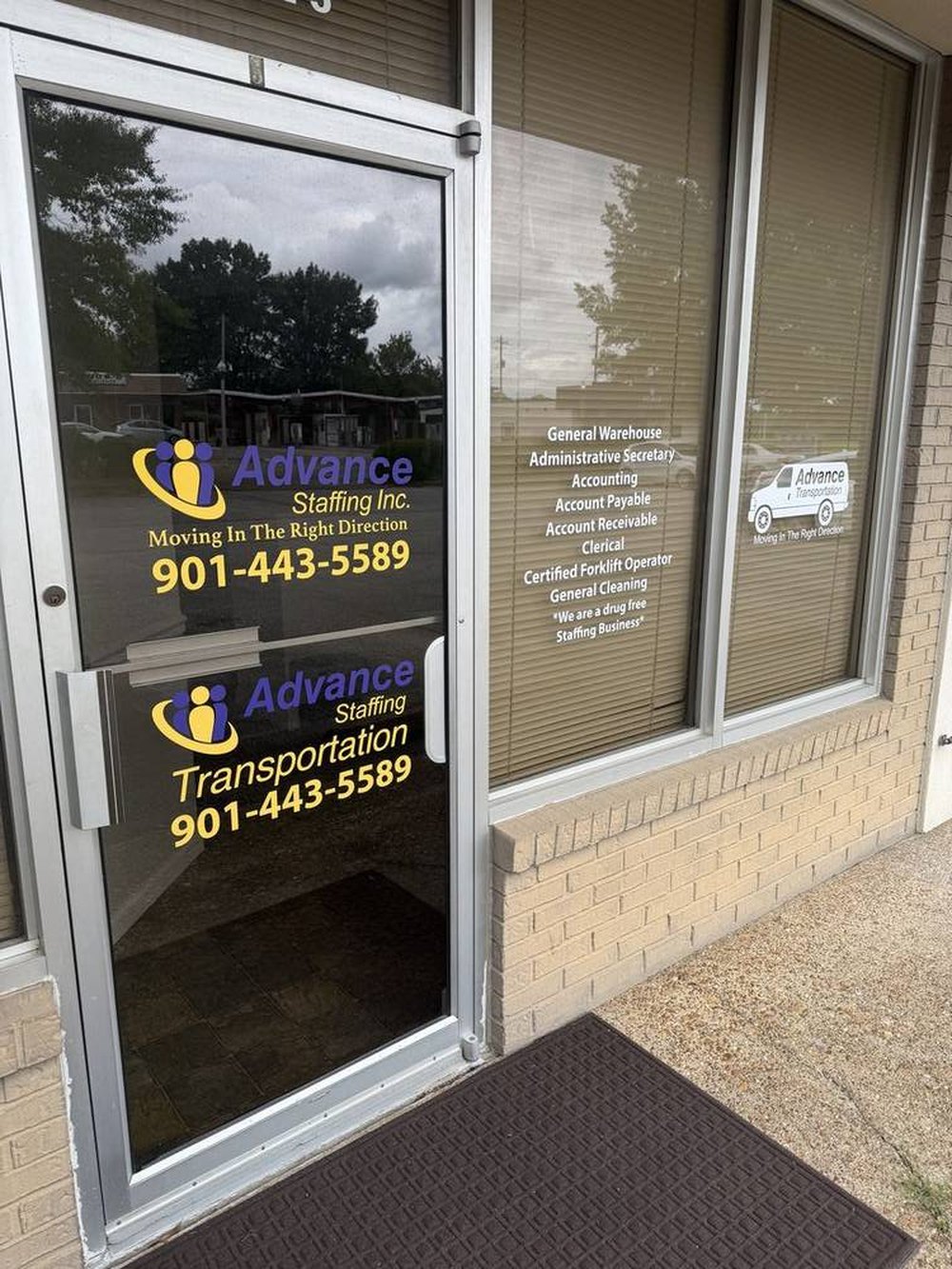 Entrance to Advance Staffing at 2840 Bartlett Rd Suite 5, with window signage listing general warehouse, administrative, accounting, clerical, certified forklift operator, and general cleaning placements